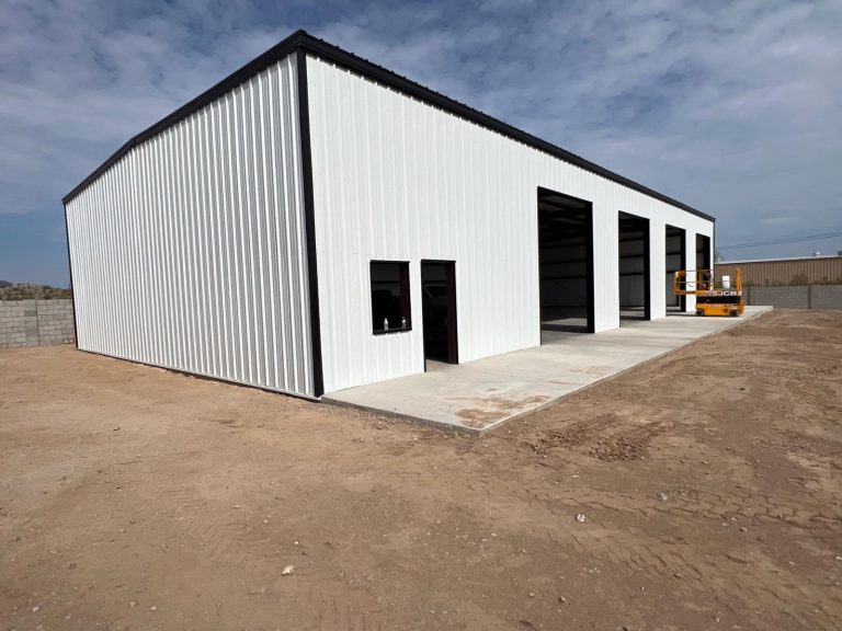 White multi-bay steel building with an office door and window