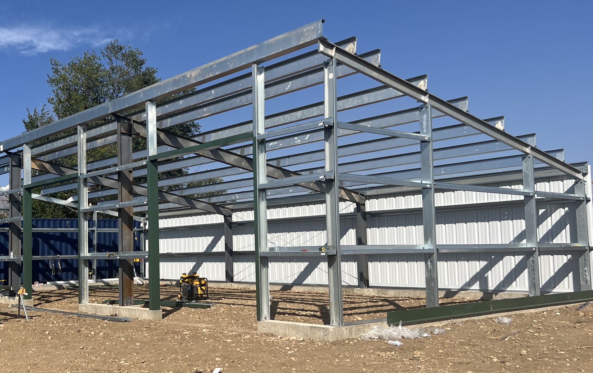 Galvanized steel frame of a shed going up, with columns, rafters and purlins before the roof panels, near Longmont, Colorado