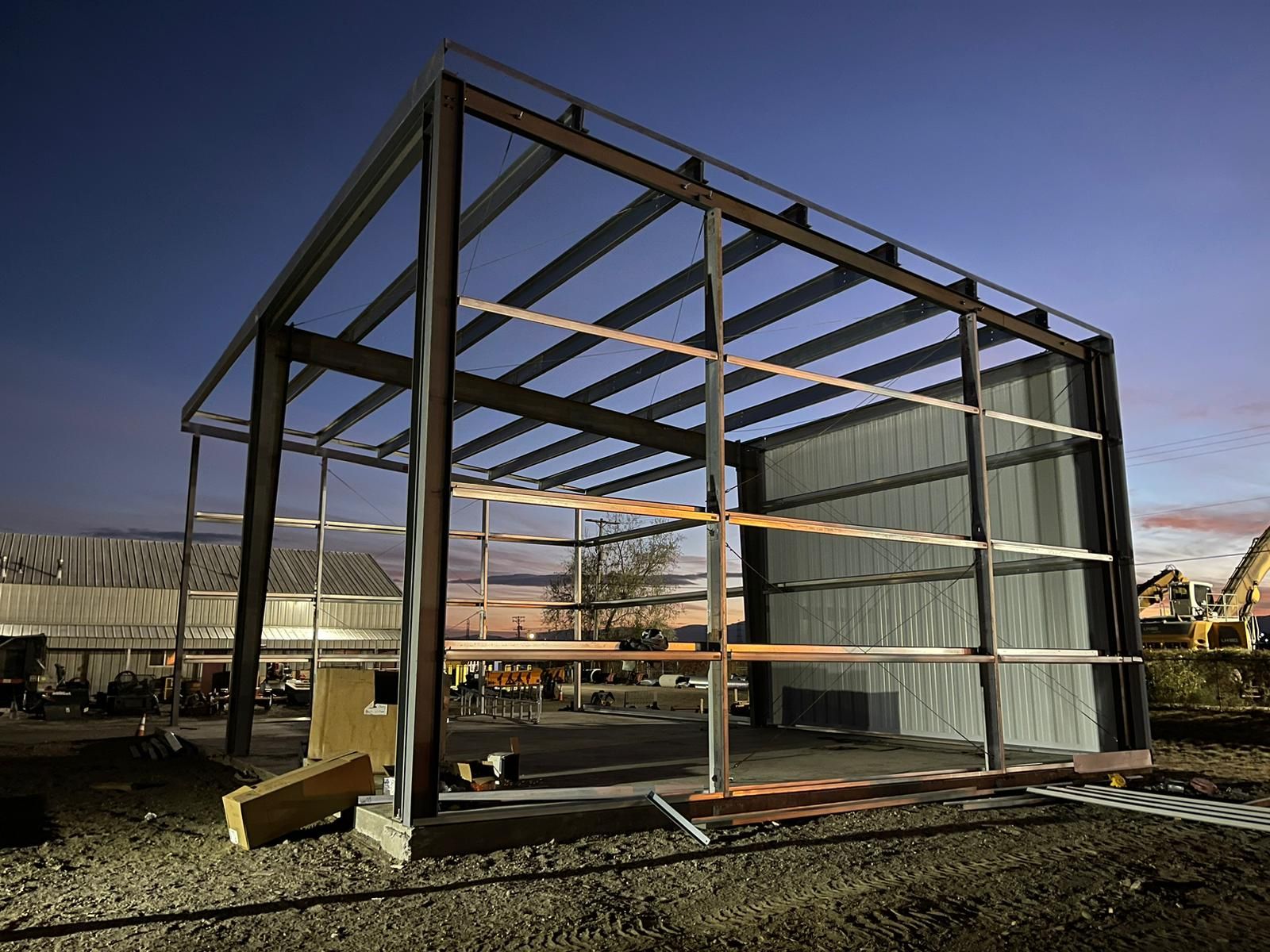 Steel building frame with girts and the first wall panels at dusk in Littleton, Colorado