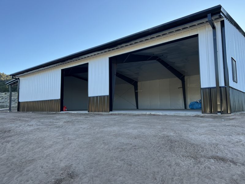 White steel building with two large open bays in Glade Park, Colorado