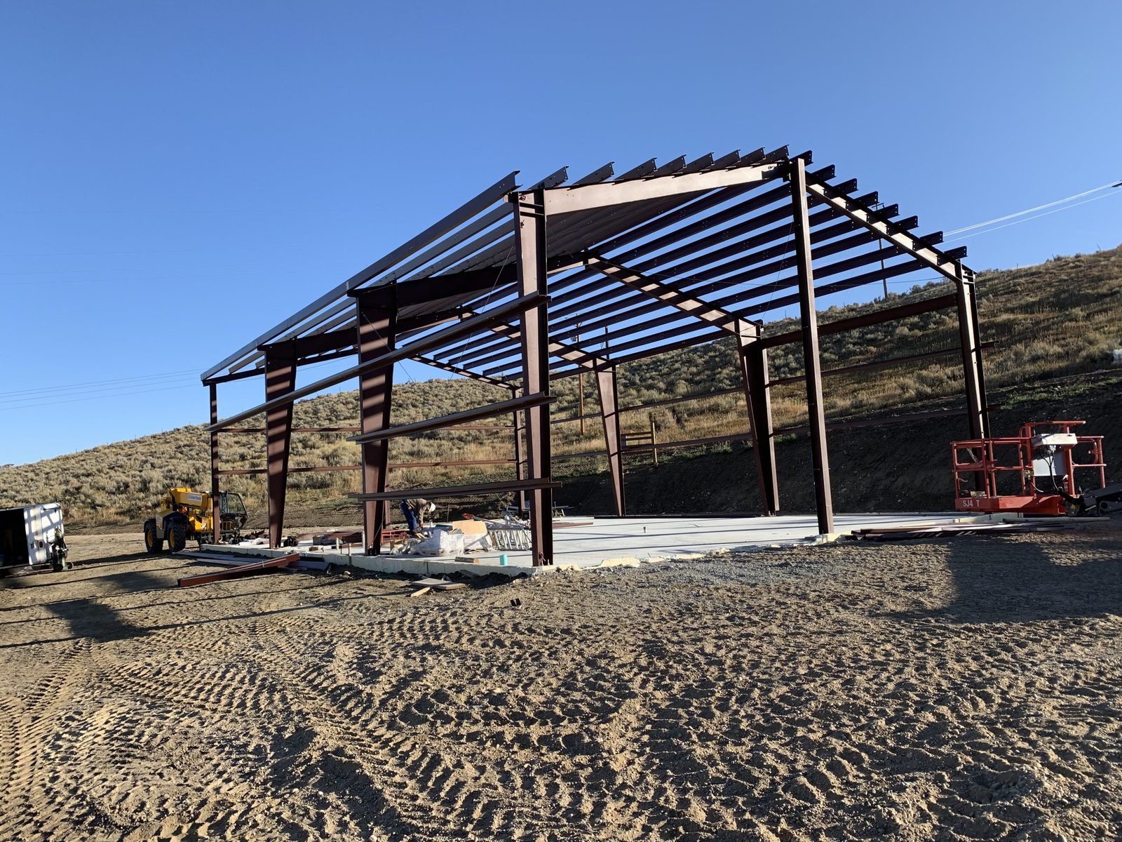 Red-oxide steel frame with roof purlins on a concrete slab