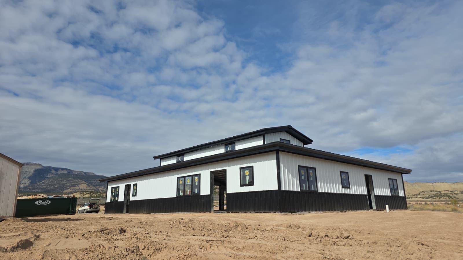 Steel building on a barn property under a cloudy sky