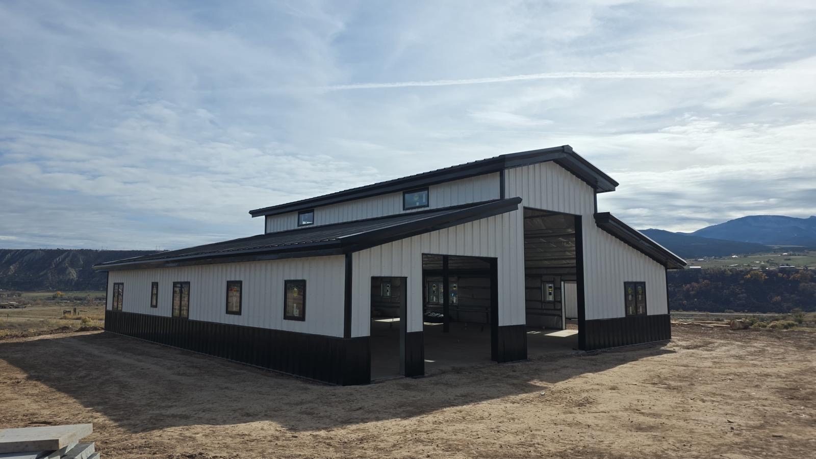 White monitor-style steel barn with black wainscot